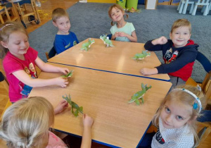 Dzieci prezentują wykonanego dinozaura.